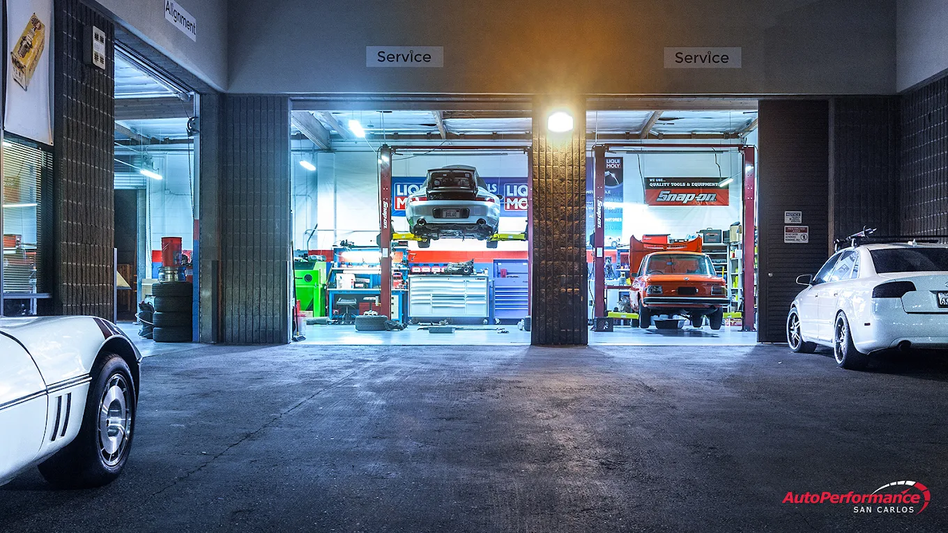 AutoPerformance San Carlos shop bays at night with service vehicles